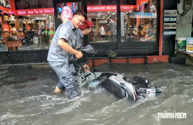 Đường Mã Lò (phường Bình Trị Đông, TP.HCM) bị ngập, ô tô đi qua tạo sóng xô đổ xe máy