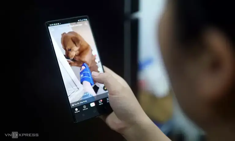 Một người dùng đang xem video giải trí trên điện thoại di động. Ảnh: Lưu Quý