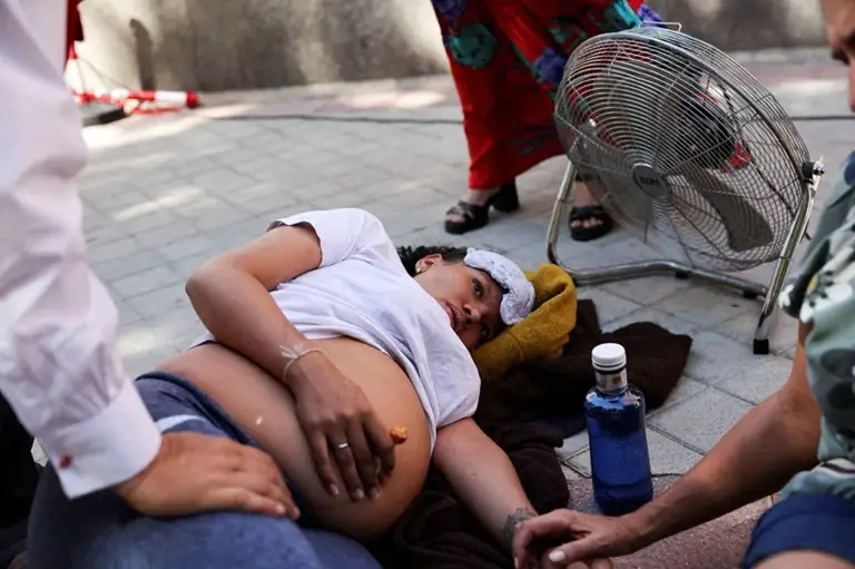 Một phụ nữ mang thai bị say nắng tại thủ đô Madrid, Tây Ban Nha vào tháng 8-2023 - Ảnh: REUTERS
