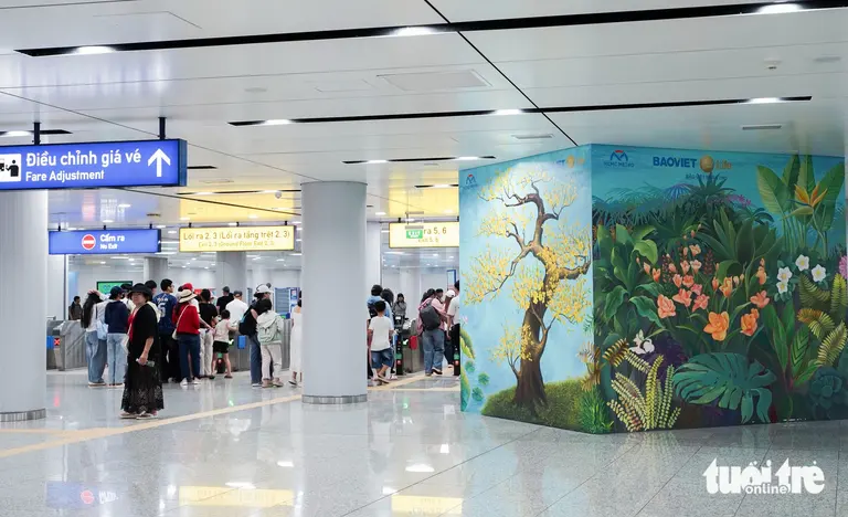 Bộ tranh "Việt Nam bốn mùa hoa" thu hút nhiều hành khách tại cổng ra nhà ga metro Bến Thành - Ảnh: HỮU DUY