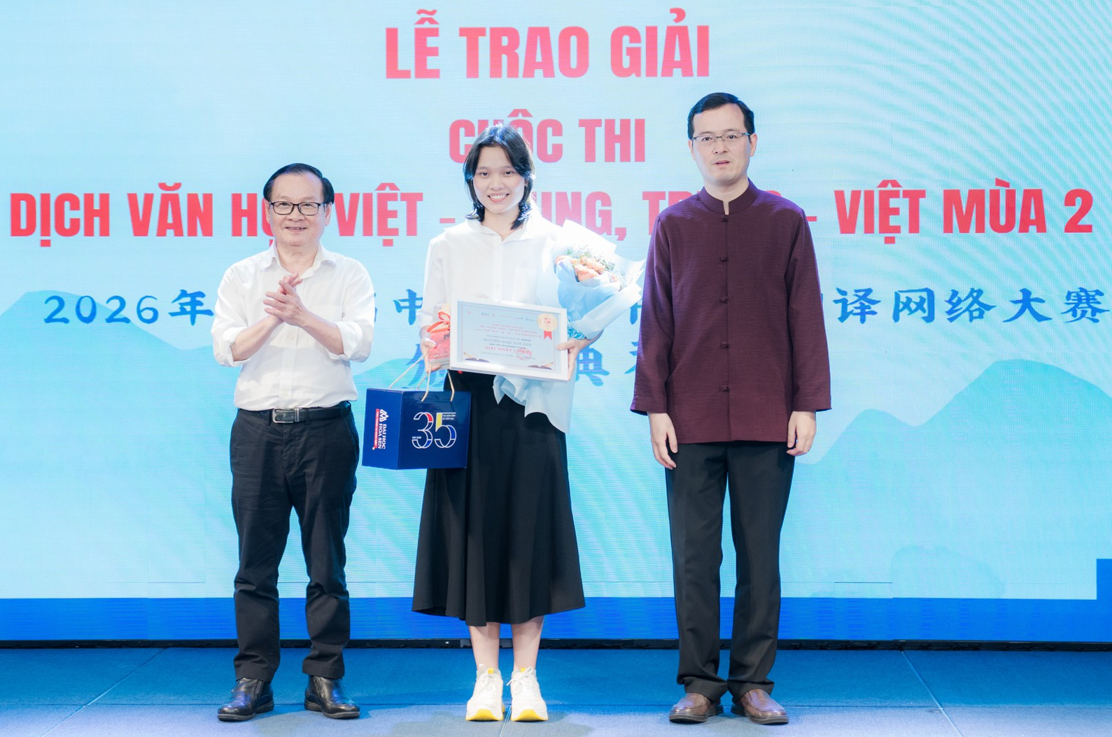 Nhà văn Nguyễn Nhật Ánh (bìa trái) cùng quyền Tổng lãnh sự Trung Quốc Từ Châu trao giải nhất cuộc thi hạng mục dịch Việt - Trung cho sinh viên Nguyễn Ngọc Kim Ánh, Trường đại học Khoa học xã hội và Nhân văn TP.HCM - Ảnh: Lucy