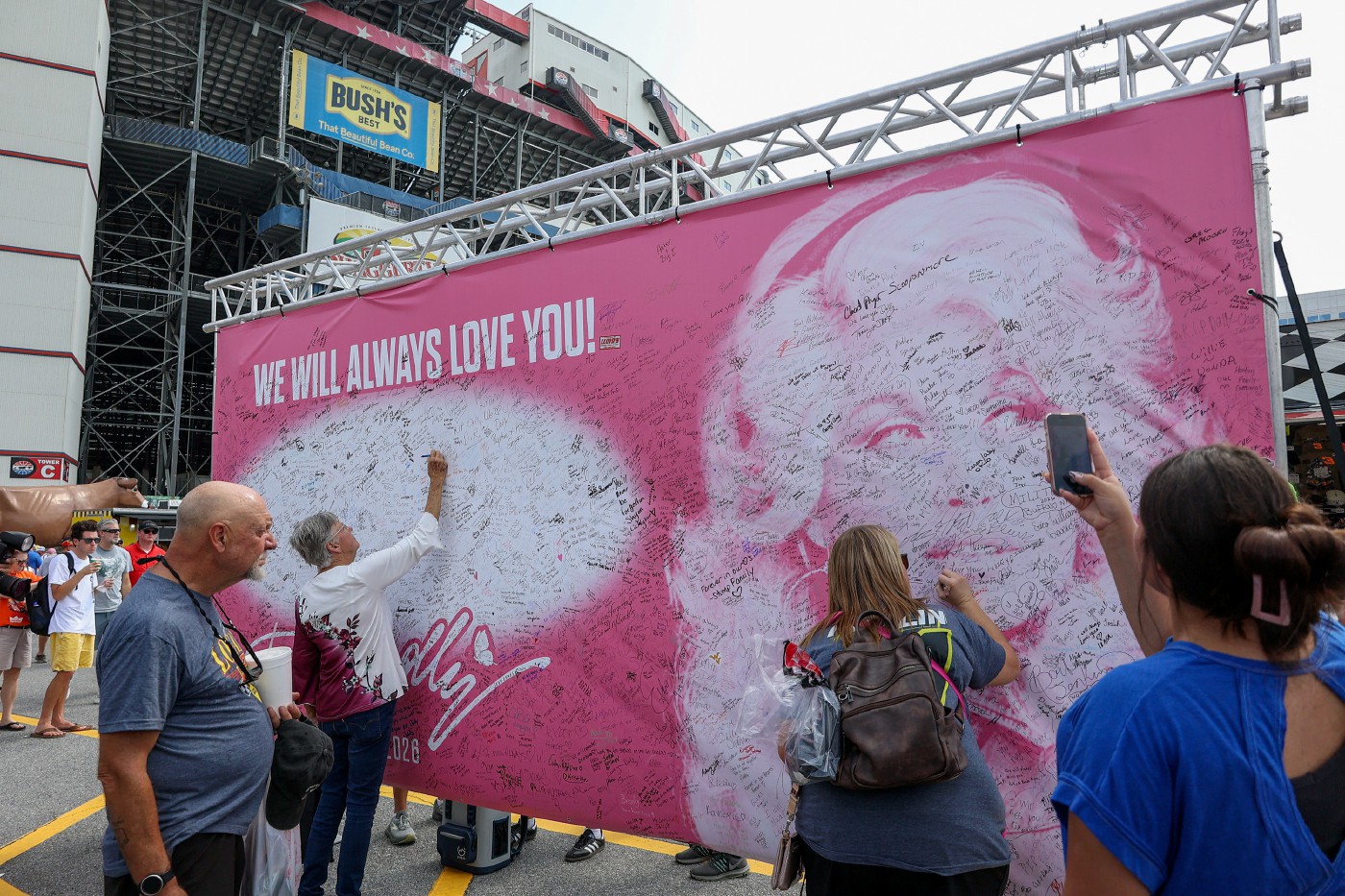 Người hâm mộ ký tên lên tấm biển tri ân Dolly Parton tại đường đua Bristol Motor Speedway ở Bristol, Tennessee - Ảnh: Reuters