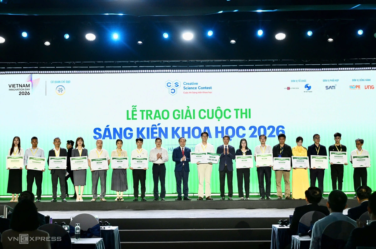 Bộ trưởng Khoa học và Công nghệ Vũ Hải Quân, ông Phạm Hiếu, Tổng biên tập báo VnExpress và ông Lưu Hoàng Long, Cục trưởng Sở hữu trí tuệ và các tác giả được giải Cuộc thi Sáng kiến Khoa học 2026. Ảnh: Giang Huy