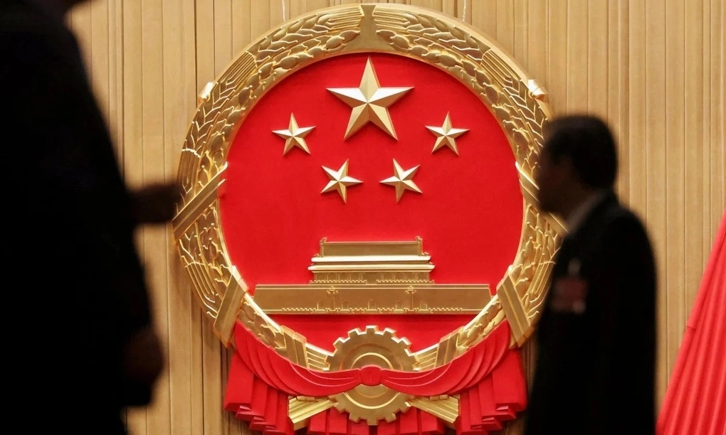 Các đại biểu đi qua quốc huy Trung Quốc tại Đại Lễ đường Nhân dân ở Bắc Kinh trước một phiên họp quốc hội hồi tháng 3. Ảnh: Reuters