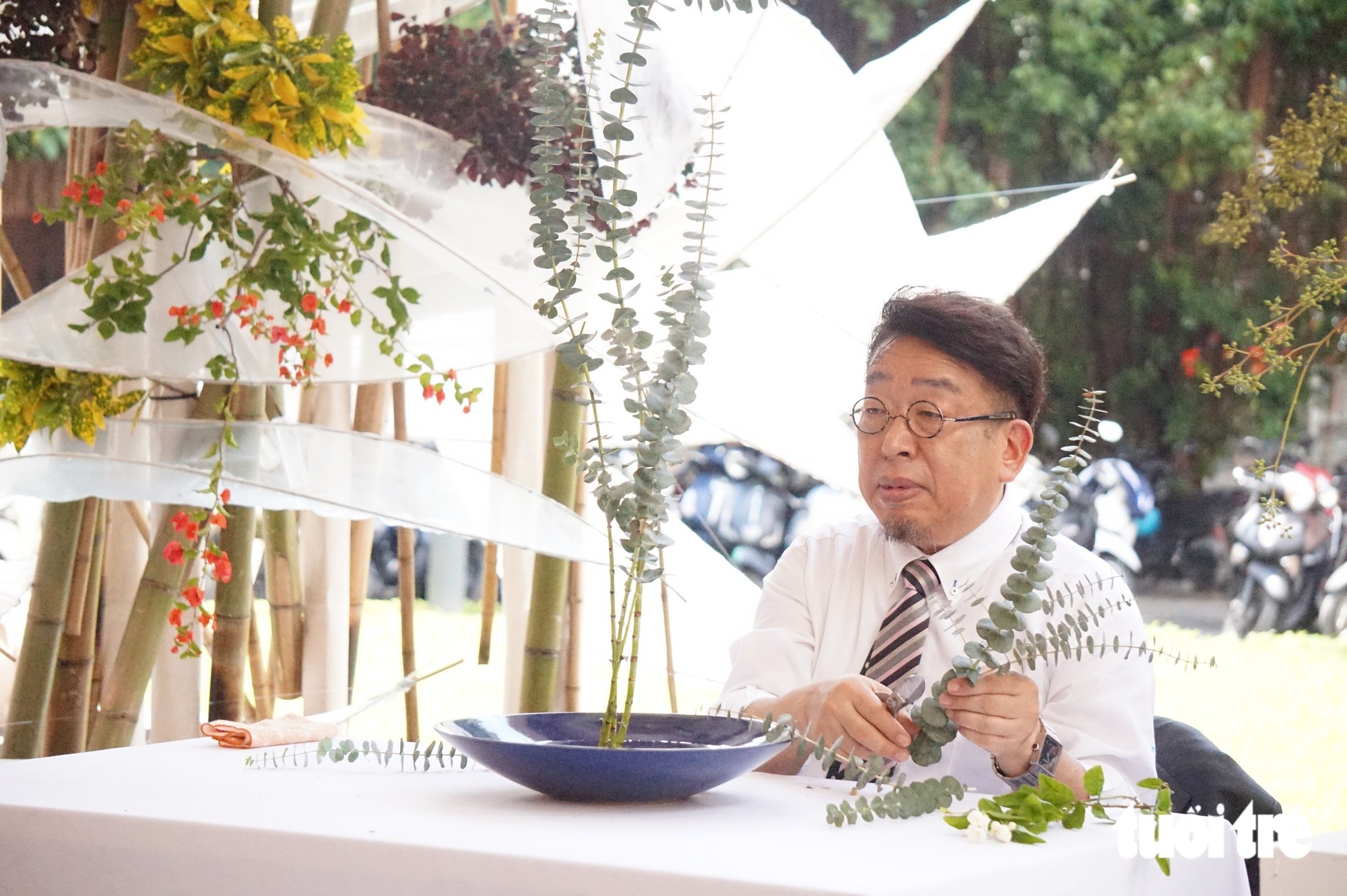 Giáo sư Furukawa Hirotaka vừa cắm tác phẩm Shoka đón khách, vừa nói về cái cúi đầu cảm ơn hoa của người Nhật - Ảnh: THIÊN ĐIỂU