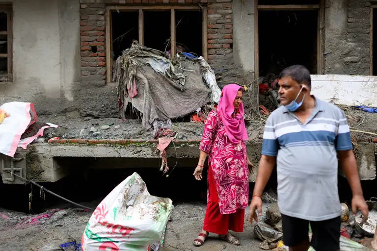Người dân Nepal tìm kiếm vật dụng còn sót lại trong ngôi nhà bị bùn vùi lấp sau lũ quét vào sáng 29-8 - Ảnh: AFP