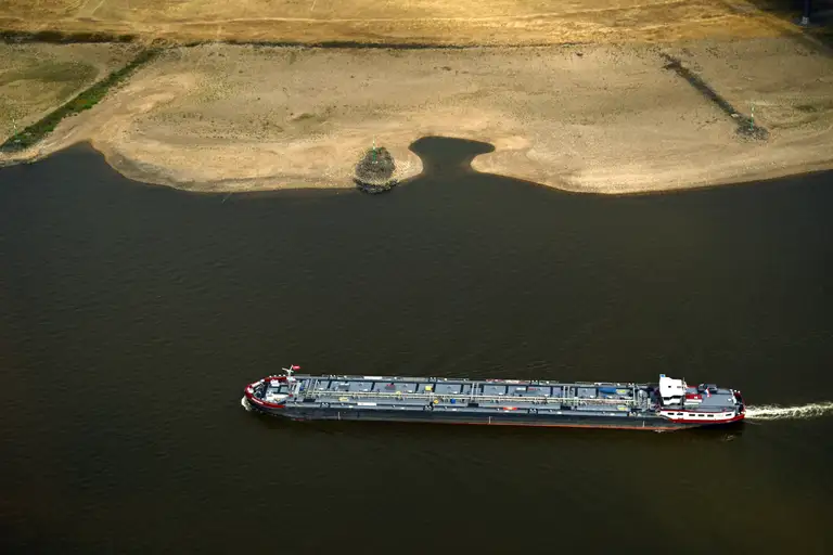 Một con thuyền đi qua đoạn lòng sông Rhine khô cạn một phần tại Dusseldorf, miền tây nước Đức, ngày 20-8, sau đợt nắng nóng bất thường - Ảnh: AFP
