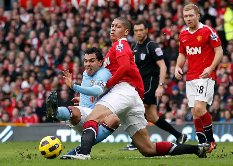 Carlos Tevez tranh chấp bóng với Chris Smalling trong một trận đấu ở Old Trafford, Manchester ngày 12/2/2011. Ảnh: Reuters