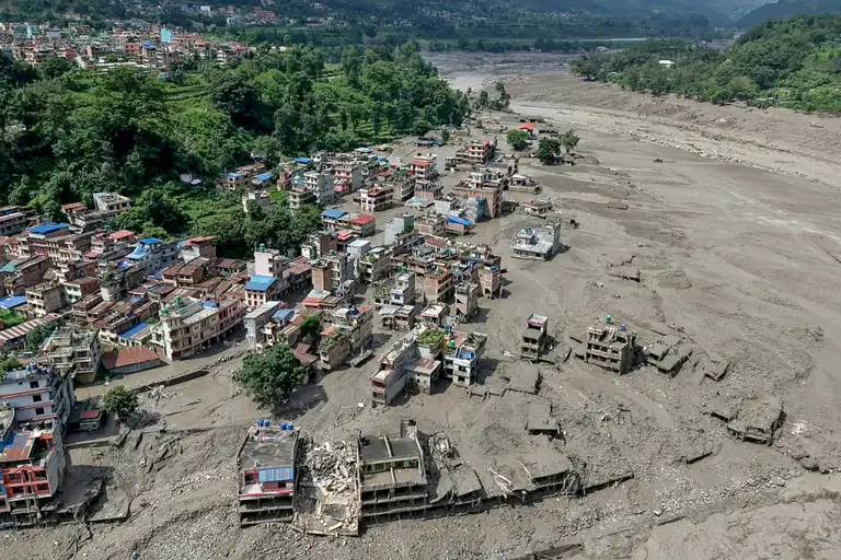 Những ngôi nhà ngập một phần trong nước bùn ven sông tại Trishuli Bazar, huyện Nuwakot, Nepal. Ảnh: AFP