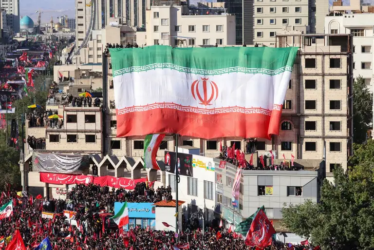 Lá cờ Iran khổng lồ tung bay trên mặt tiền một tòa nhà ở Mashhad ngày 9-7 - Ảnh: AFP