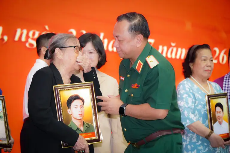 Thiếu tướng Nguyễn Thành Trung, Chính ủy Bộ Tư lệnh TP.HCM, thăm hỏi thân nhân liệt sĩ nhận di ảnh được phục dựng