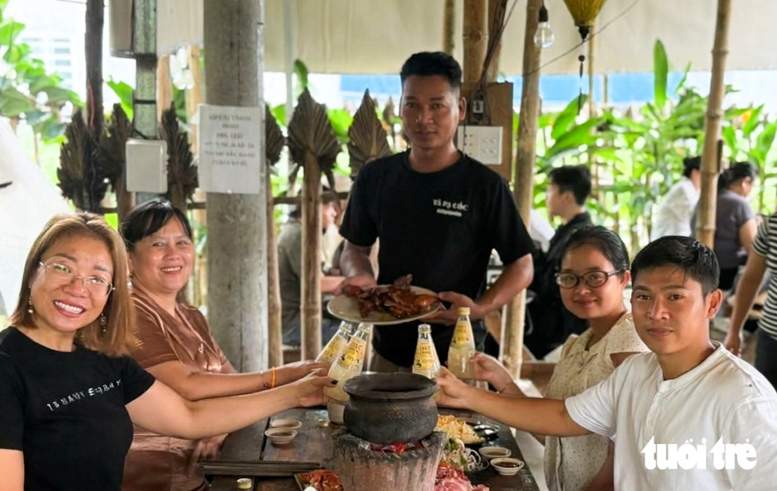 Anh Nep Ri No (đứng, chủ quán Tà Pạ Cóc, xã Tri Tôn, tỉnh An Giang) cho biết du khách đến quán anh thường chọn món bò nhúng lá chúc - Ảnh: CHÍ CÔNG