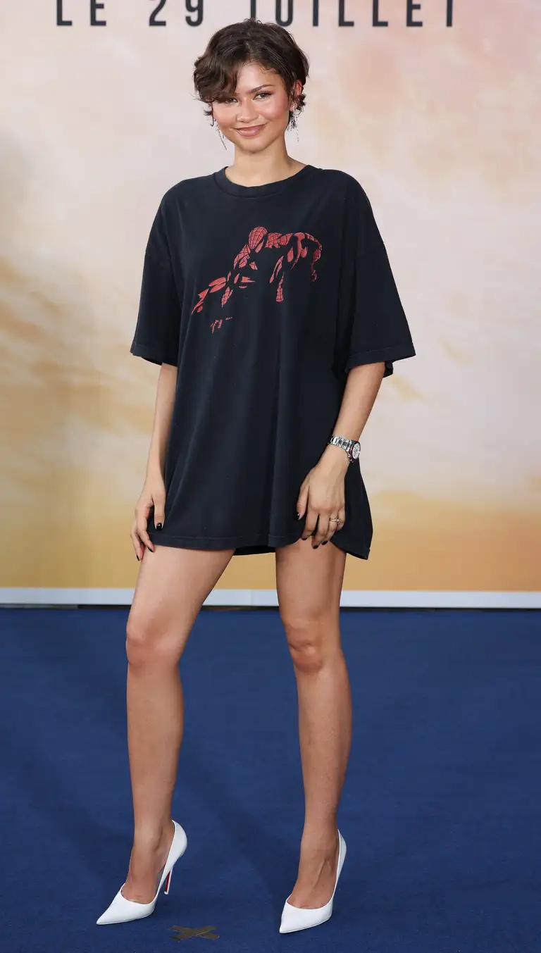 Tại Paris, Zendaya bất ngờ đổi hướng khi lựa chọn một chiếc áo thun Marvel có giá chỉ khoảng 35 USD từ đầu những năm 2000. Được săn tìm trên eBay, chiếc áo mang đậm tinh thần hoài niệm này được Zendaya biến tấu thành một chiếc váy ngắn - Ảnh: Marc