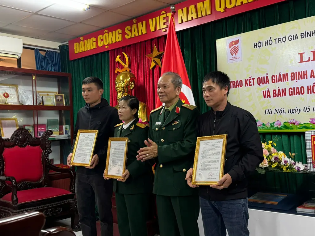 Ông Đào Công Sức (bìa phải) tiếp nhận kết quả giám định ADN của liệt sĩ Huân. Ảnh: Gia đình cung cấp