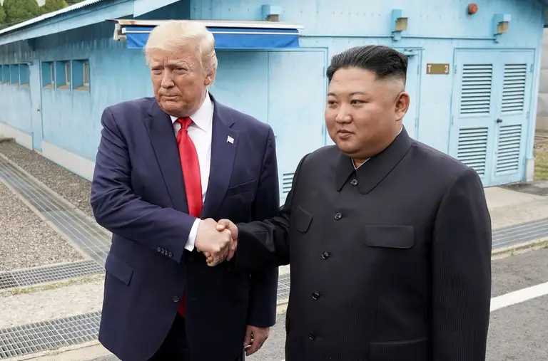 Ông Trump và ông Kim bắt tay nhau khi cả hai đến thăm khu vực phi quân sự giữa Triều Tiên và Hàn Quốc trong nhiệm kỳ tổng thống đầu tiên của ông Trump - Ảnh: REUTERS