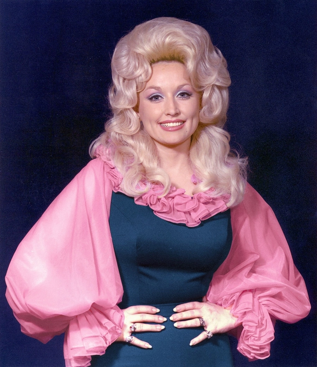 Dolly Parton nổi tiếng với hình ảnh ăn vận cầu kỳ, sặc sỡ, mái tóc phồng giống búp bê. Ảnh: Instagram Dolly Parton