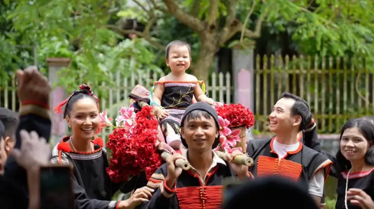 Bé Harley ngồi kiệu bằng tre ở bữa tiệc.