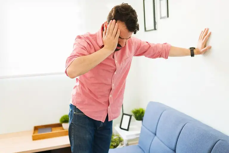 Nếu một người vốn bình thường đột nhiên phải vịn vào tường, ngồi xuống vì mất thăng bằng thì đó không chỉ là tụt huyết áp hay mệt mỏi - Ảnh: Health.Yahoo
