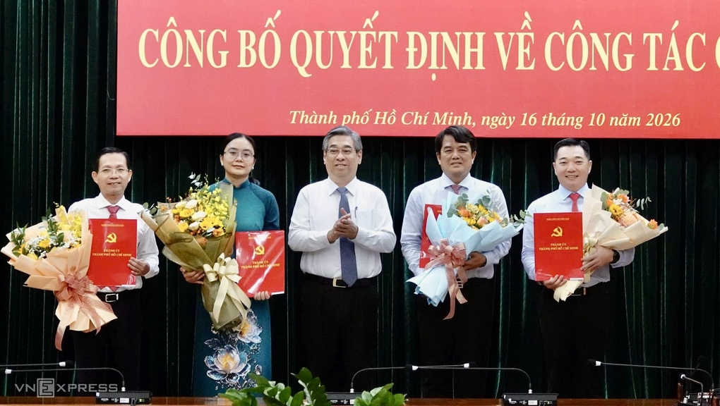 Từ phải qua, ông Lê Trương Hải Hiếu, ông Bùi Thanh Nhân, bà Hồ Thị Ánh Tuyết, ông Lê Văn Phong nhận quyết định và chúc mừng từ Phó bí thư Thành ủy Nguyễn Phước Lộc, sáng 16/10. Ảnh: An Phương