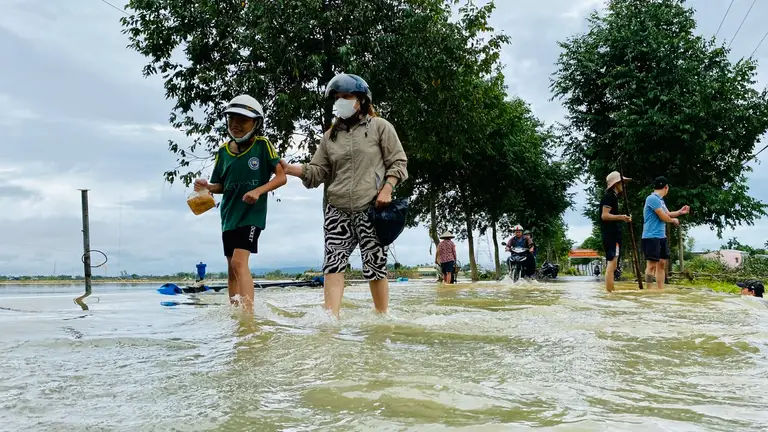 Người dân thôn Tây An, xã Hòa Châu (nay là phường Hòa Xuân) trở về nhà sau đợt lụt tháng 10-2025 - Ảnh: TRƯỜNG TRUNG