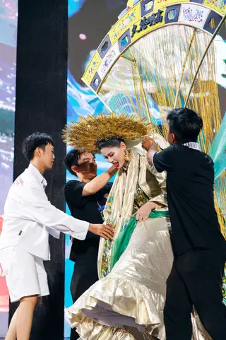 Ê kíp phải hỗ trợ ứng viên vì trang phục văn hóa dân tộc có trọng lượng khá lớn, nặng - Ảnh: KIẾNG CẬN STUDIO