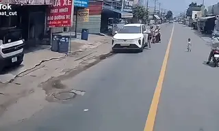 Cậu bé chạy theo người lớn qua đường ngay trước đầu ôtô