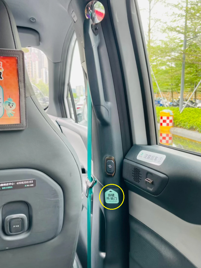 Hướng dẫn nút bấm đóng/mở cửa (khoanh vàng) trên một chiếc robotaxi ở Trung Quốc. Trên bậu cửa kính là lời nhắc cẩn thận khi mở cửa. Ảnh: smzdm