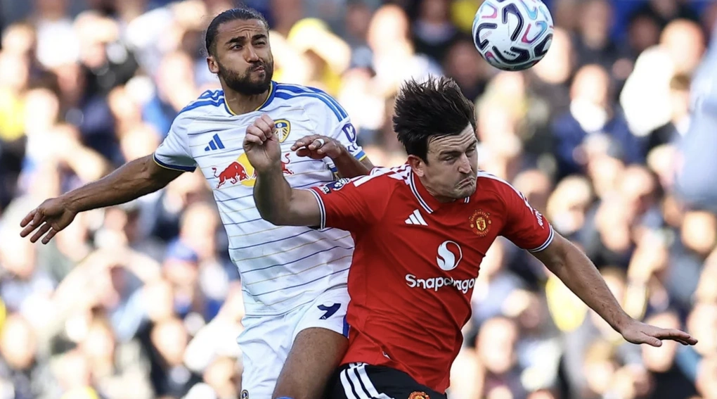 Harry Maguire (áo đỏ) tranh chấp bóng bổng với Calvert-Lewin. Ảnh: Reuters