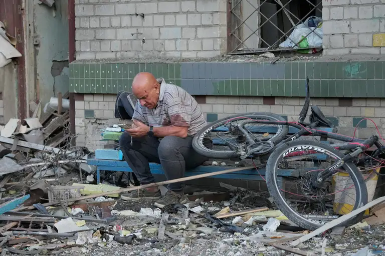 Một người đàn ông ngồi giữa đống đổ nát sau một vụ tập kích ở Kiev ngày 2/7. Ảnh: AP