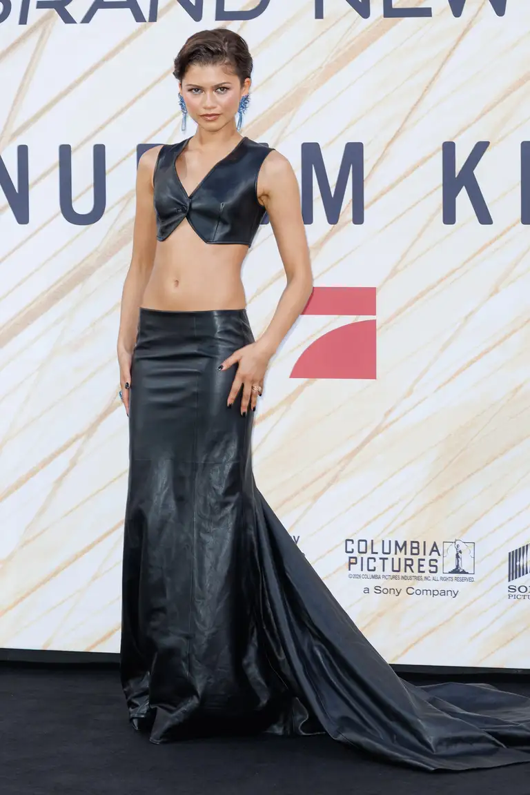 Cho lần xuất hiện thứ hai tại Berlin, Zendaya tiếp tục diện đồ của Louis Vuitton. Được chế tác hoàn toàn từ chất liệu da đen, bộ trang phục hai mảnh gồm chiếc áo ghi lê dáng ngắn ôm sát cơ thể và chân váy cạp trễ với phần đuôi váy dài quét đất đầy kịch tính - Ảnh: Gerome Defrance