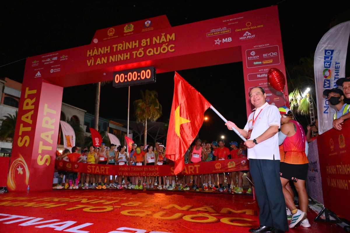 Thiếu tướng Lê Xuân Đức, Chánh Văn phòng Hiệp hội Thể thao Công an nhân dân, thực hiện nghi thức phất cờ để bắt đầu cự ly marathon. Ảnh: VnExpress Marathon