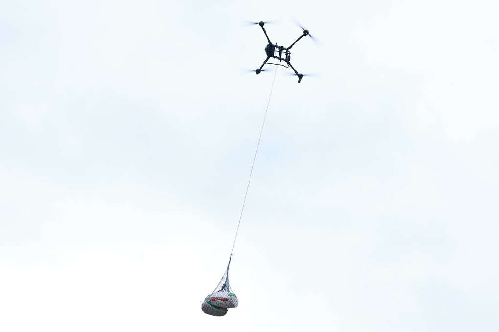 Những bao cà phê sau thu hoạch được chuyển từ vùng sản xuất xuống núi bằng UAV. Ảnh: Đàm Minh