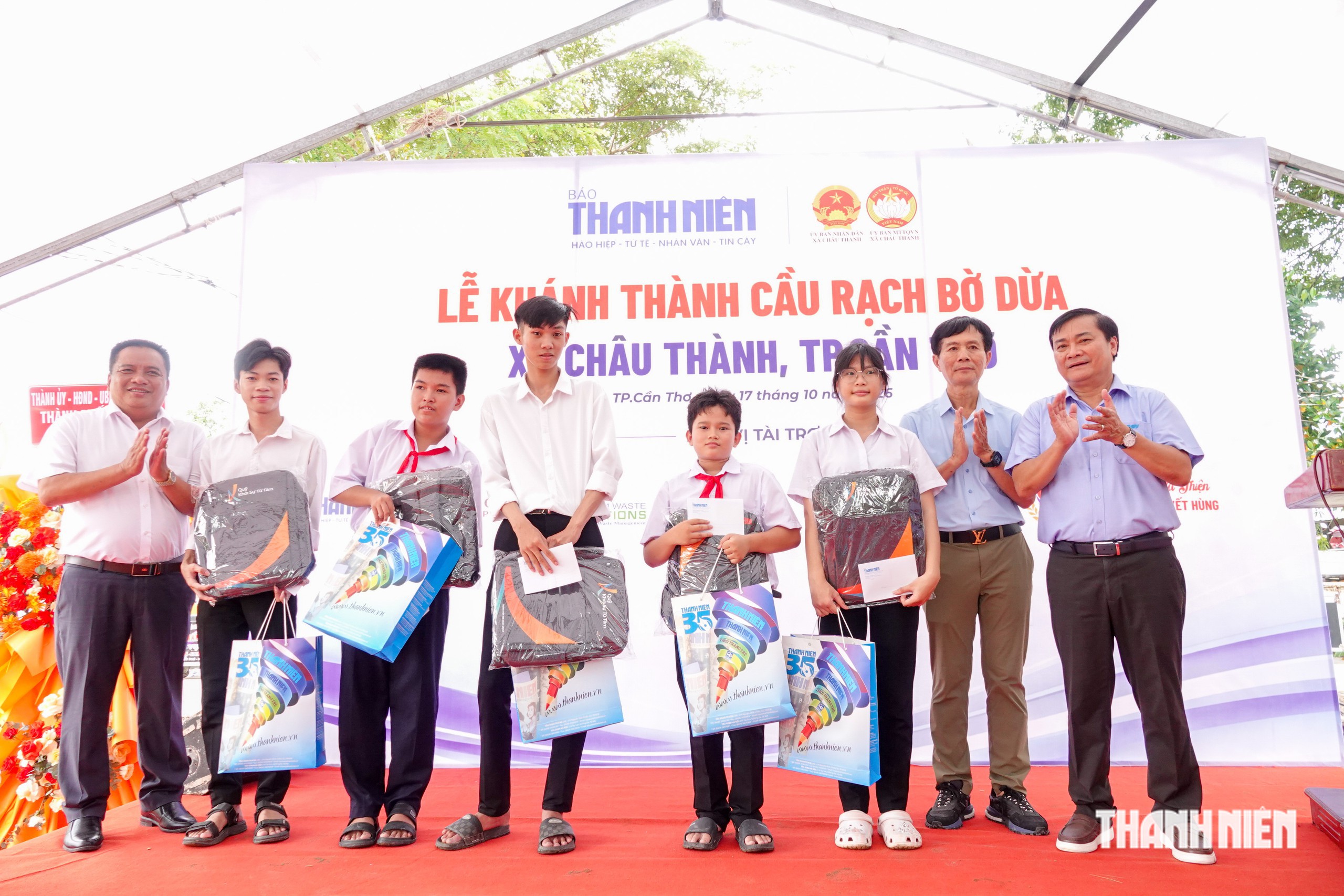 Các em học sinh nhận học bổng và quà tặng của Báo Thanh Niên cùng ông Phan Văn Nhàn, Chủ tịch Hội Doanh nghiệp phường Bình Trị Đông (TP.HCM) và Quỹ Khởi Sự Từ Tâm (Kim Oanh Group)