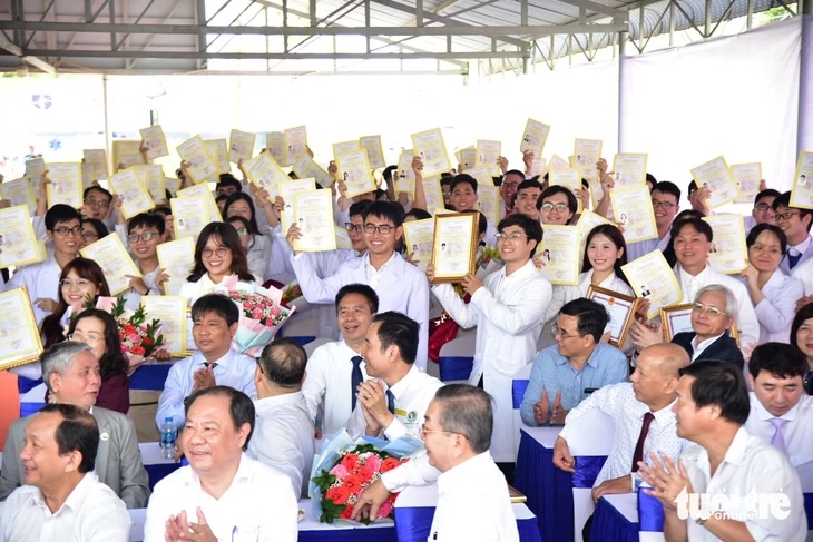 Các bác sĩ trẻ tự hào giơ cao giấy chứng nhận hoàn thành chương trình thí điểm thực hành - Ảnh: TRÍ ĐỨC