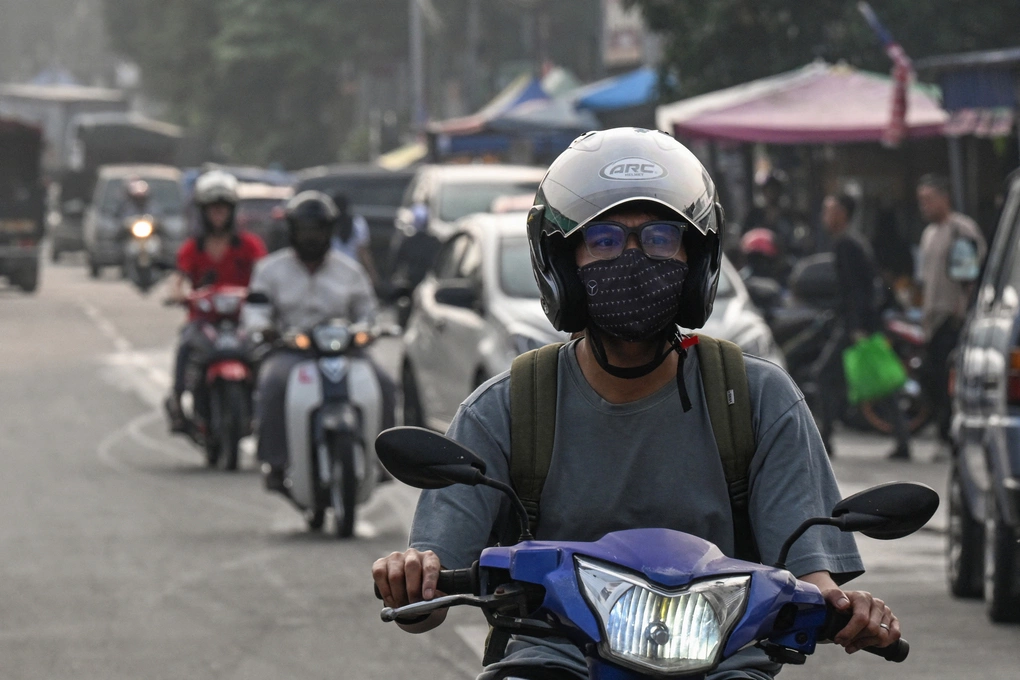 Người dân đeo khẩu trang khi di chuyển trên đường phố Kuala Lumpur hôm 17/10. Ảnh: AFP