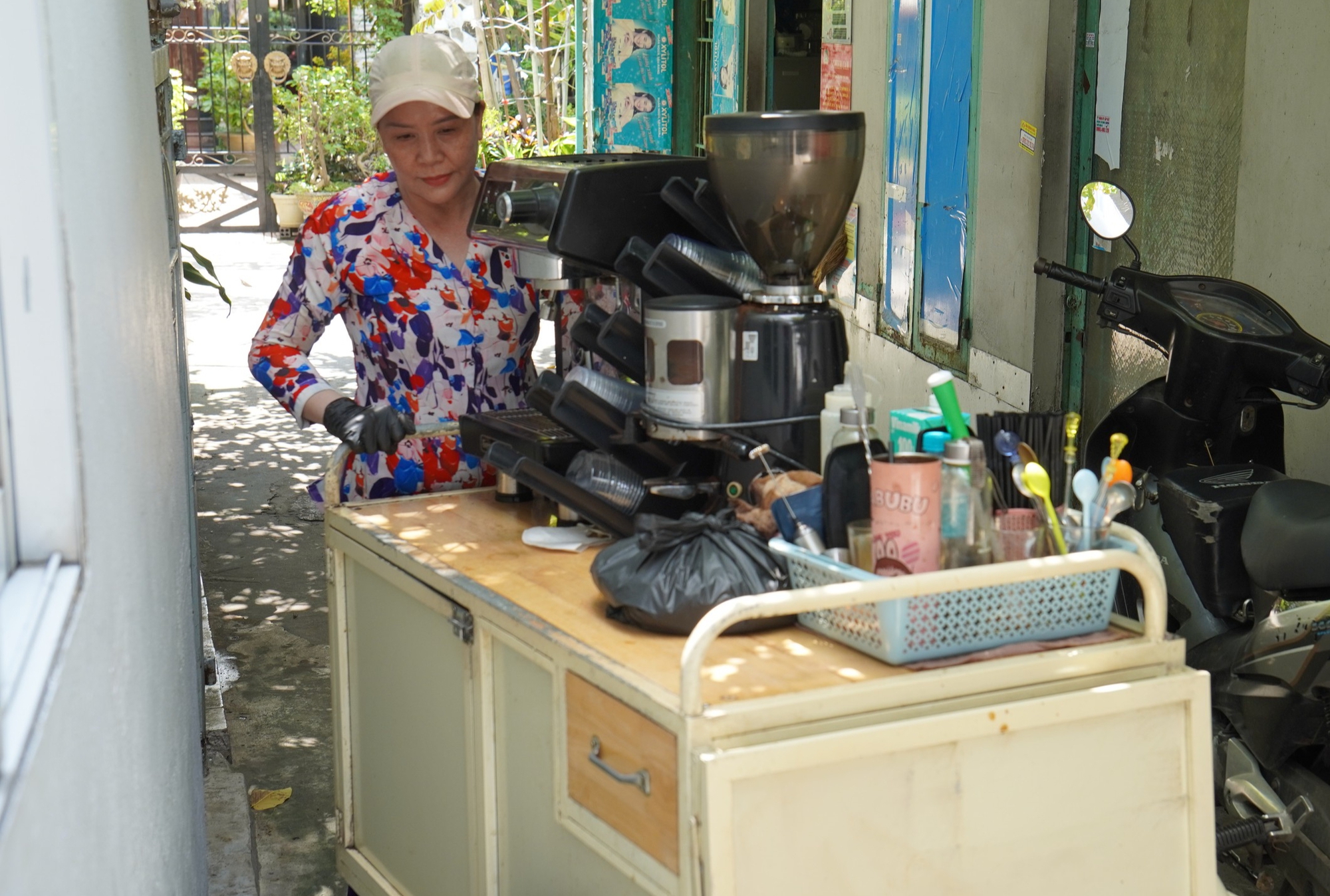 Mẹ con chị Hiền nhận được nhiều sự giúp đỡ, sẻ chia từ những người xung quanh. Trong ảnh, chị Hiền thu dọn xe cà phê sau buổi bán hàng từ 4h - 10h sáng, đến giấc xế tiếp tục làm bánh bột lọc - Ảnh: XUÂN MAI