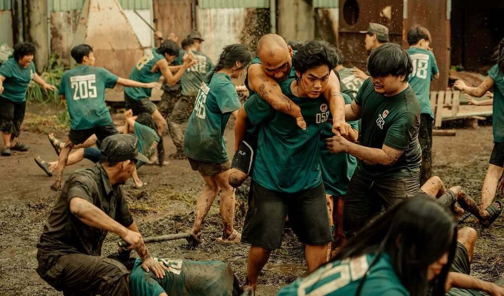 Nguyễn Hồng Lợi được bạn diễn Quang Anh cõng trên lưng ở cảnh đào tẩu khỏi cuộc bạo loạn trong phim "Trại buôn người". Ảnh: Đoàn phim cung cấp