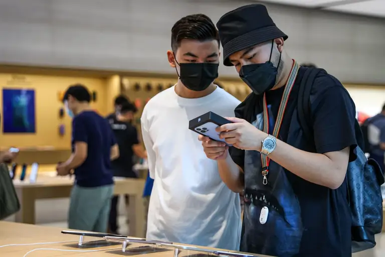 Hai khách hàng xem một mẫu điện thoại mới tại cửa hàng. Giới bán lẻ trong nước dự đoán mặt bằng giá cao sẽ được giữ tới hết năm 2026.