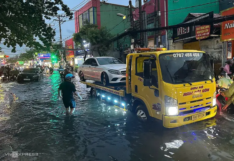 Ôtô chết máy được xe cứu hộ đưa đi trên đường Nguyễn Văn Quá - cửa ngõ Tân Sơn Nhất, chiều 30/9. Ảnh: Tuấn Việt