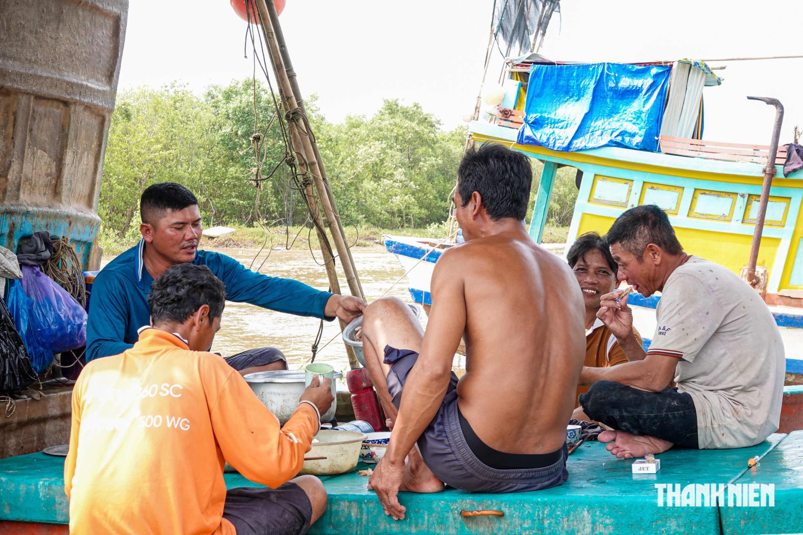 Các thuyền viên trên ghe của anh Hiệp chế biến hải sản tươi ăn cùng nhau sau khi ghe cập bến và bán cá xong