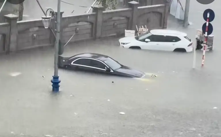 Xe ô tô đậu trên vỉa hè tại Vinh cũng bị ngập sâu