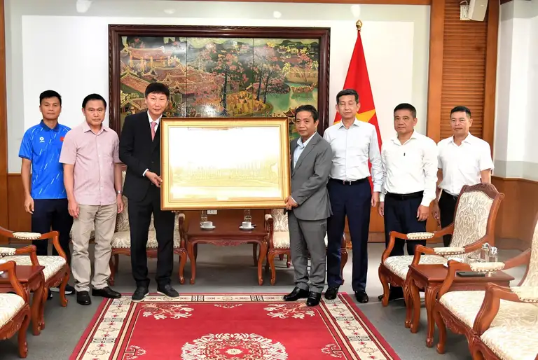 Thứ trưởng Bộ VH-TT-DL Hoàng Đạo Cương trao quà cho HLV Kim Sang-sik và đội tuyển