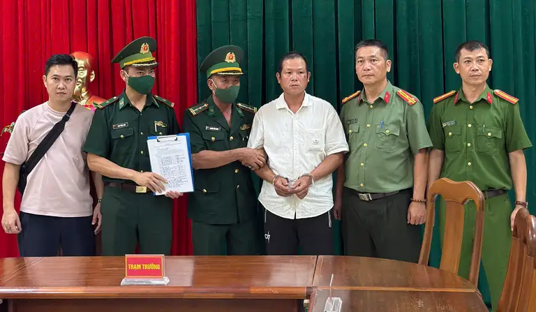 Đối tượng Nguyễn Thế Phụng (áo trắng) được áp giải từ Lào về Việt Nam