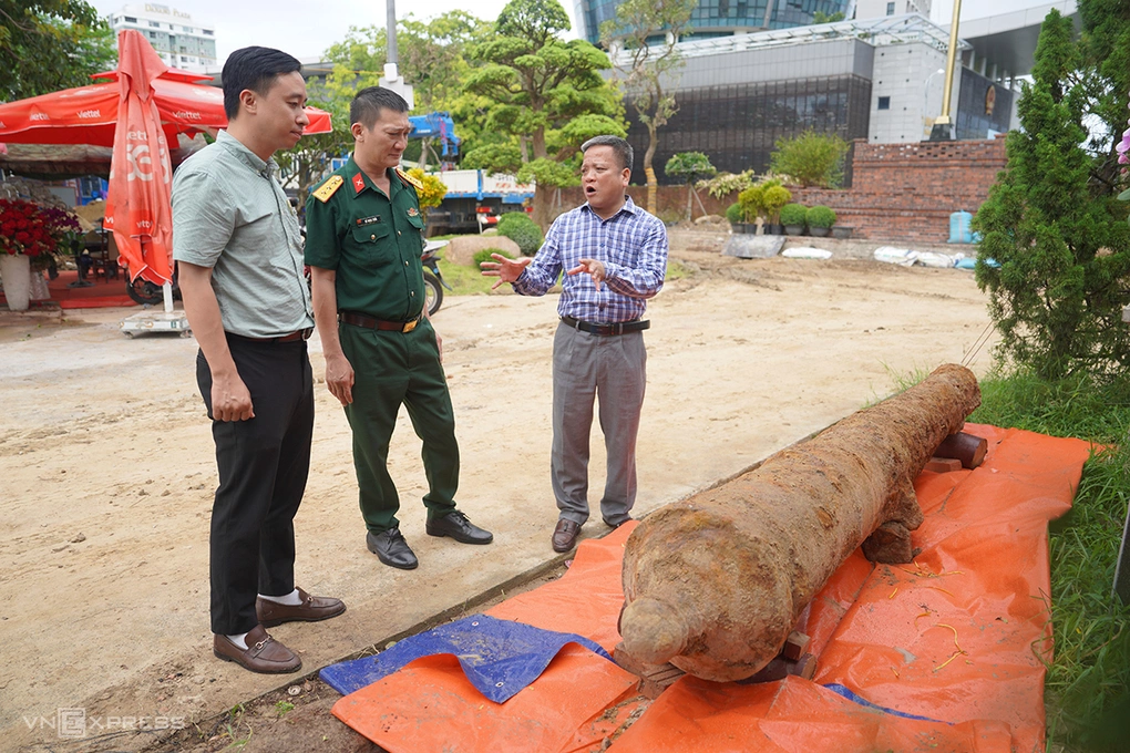 Ông Huỳnh Đình Quốc Thiện (bìa phải) trao đổi với đại diện Bộ Chỉ huy quân sự TP Đà Nẵng về súng thần công vừa phát hiện. Ảnh: Nguyễn Đông