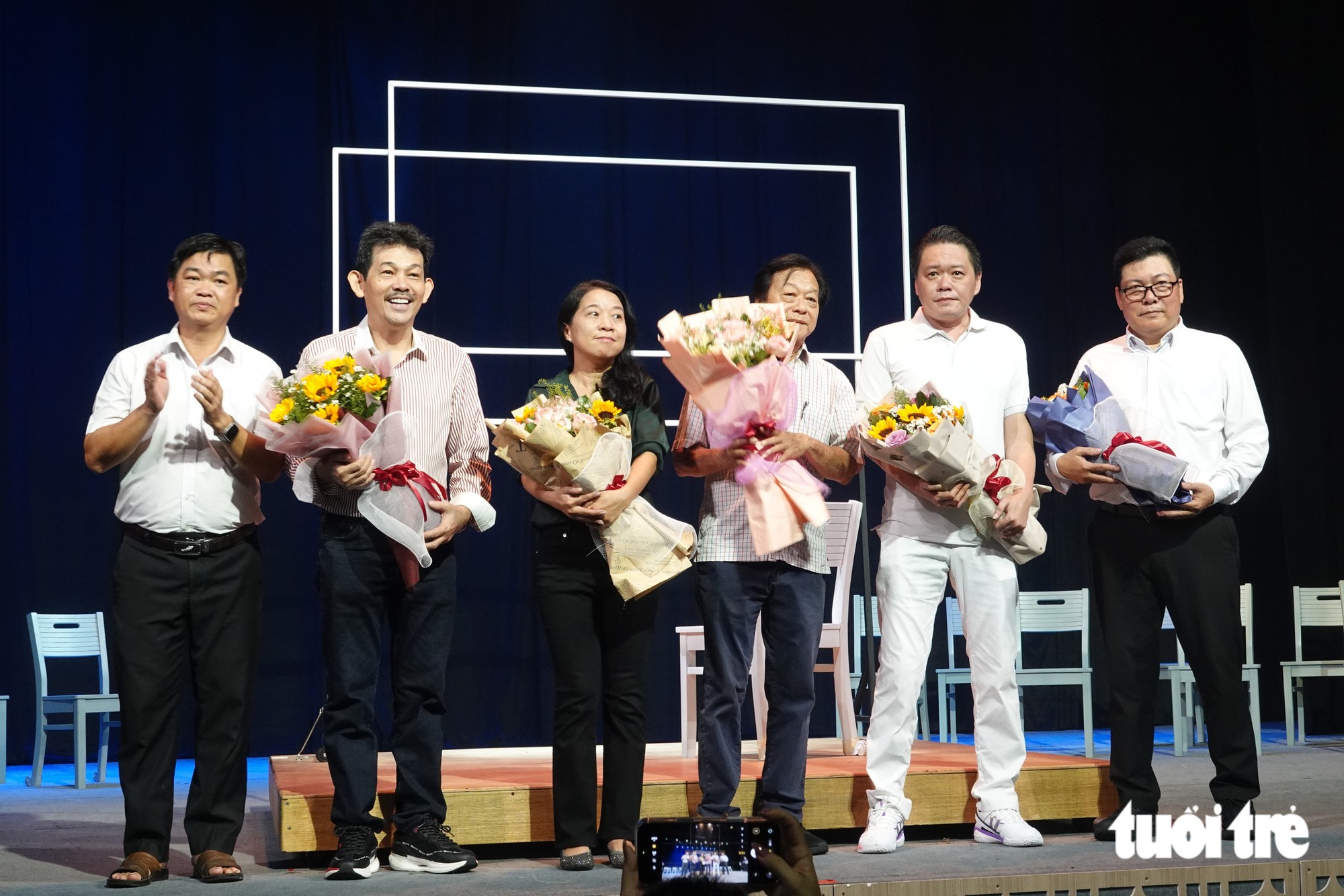 Ông Lê Văn Minh (bìa trái), Phó trưởng Ban thường trực Ban Tuyên giáo Thành ủy TP.HCM, tặng hoa cho ê kíp thực hiện vở nhạc kịch Vết xước - Ảnh: LINH ĐOAN