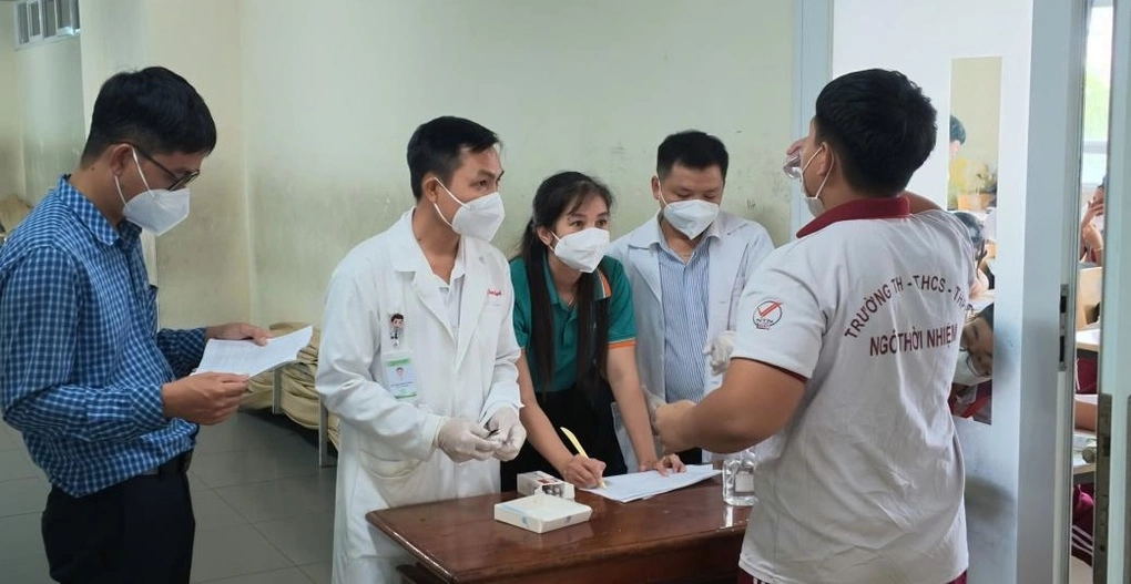 Các học sinh tiếp xúc gần với ca bệnh tại Trường TH-THCS-THPT Ngô Thời Nhiệm, phường Bình Dương được uống kháng sinh dự phòng. Ảnh: HCDC
