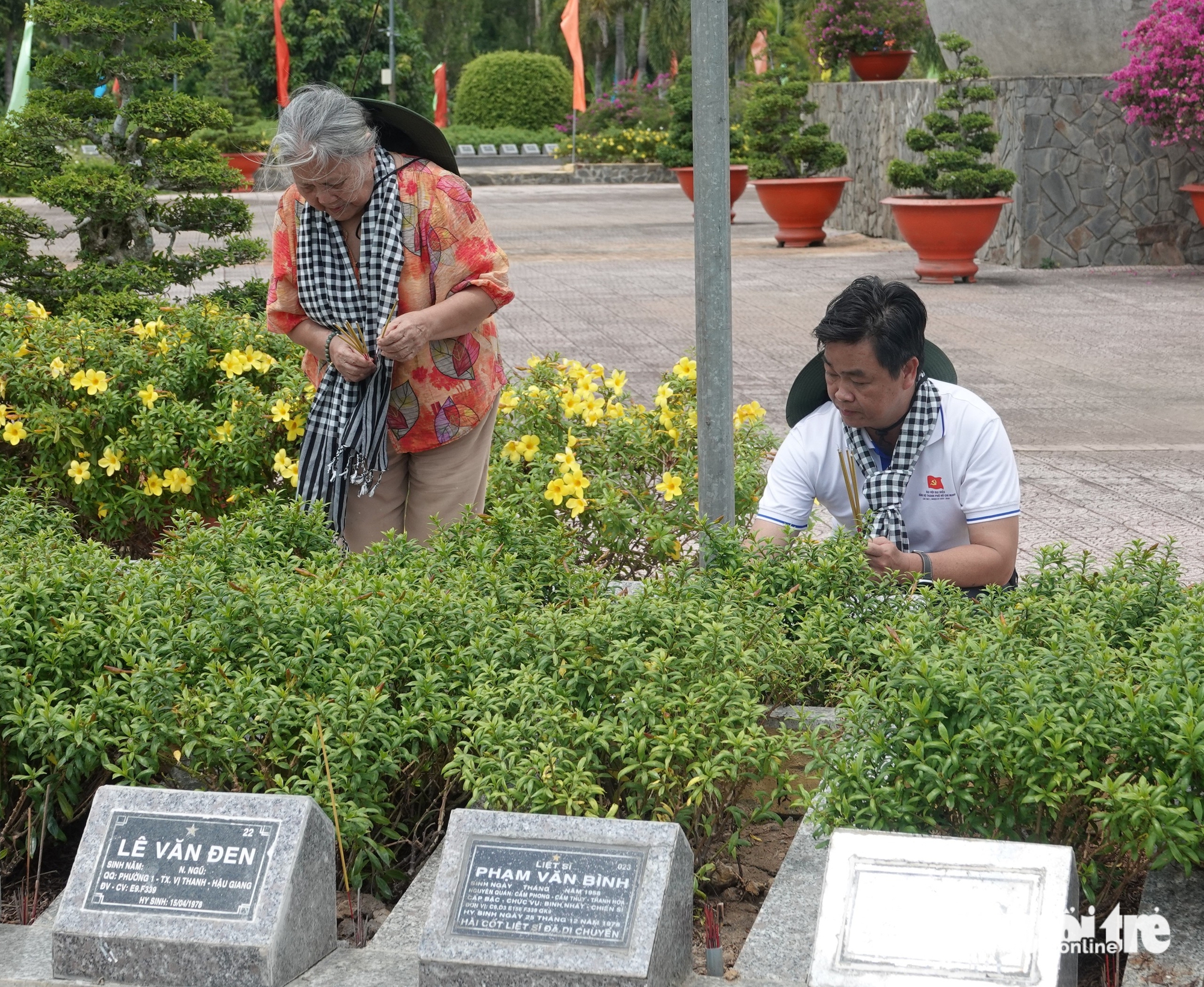 Thành ủy viên, Phó trưởng Ban thường trực Ban Tuyên giáo và Dân vận Thành ủy TP.HCM Lê Văn Minh và nghệ sĩ Lê Thiện thắp nhang tại Nghĩa trang liệt sĩ Tam Nông - Ảnh: LINH ĐOAN