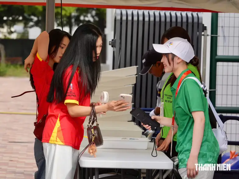 Một nữ CĐV làm thủ tục kiểm tra an ninh trong nụ cười vui vẻ của nữ tình nguyện viên nước chủ nhà Nhật Bản tại ASIAD 2026