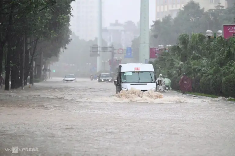 Ôtô di chuyển trong dòng nước ngập gần hết bánh xe. Ảnh: Phạm Chiểu