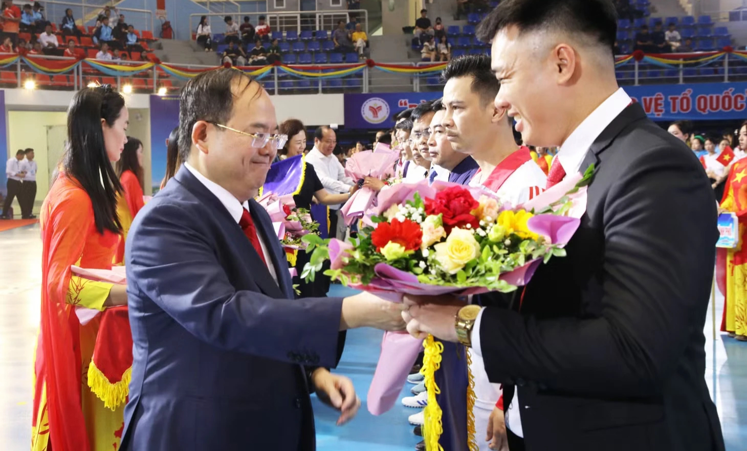Bí thư Thành ủy Quảng Ninh Quản Minh Cường (bìa trái) tặng hoa chúc mừng các đoàn vận động viên